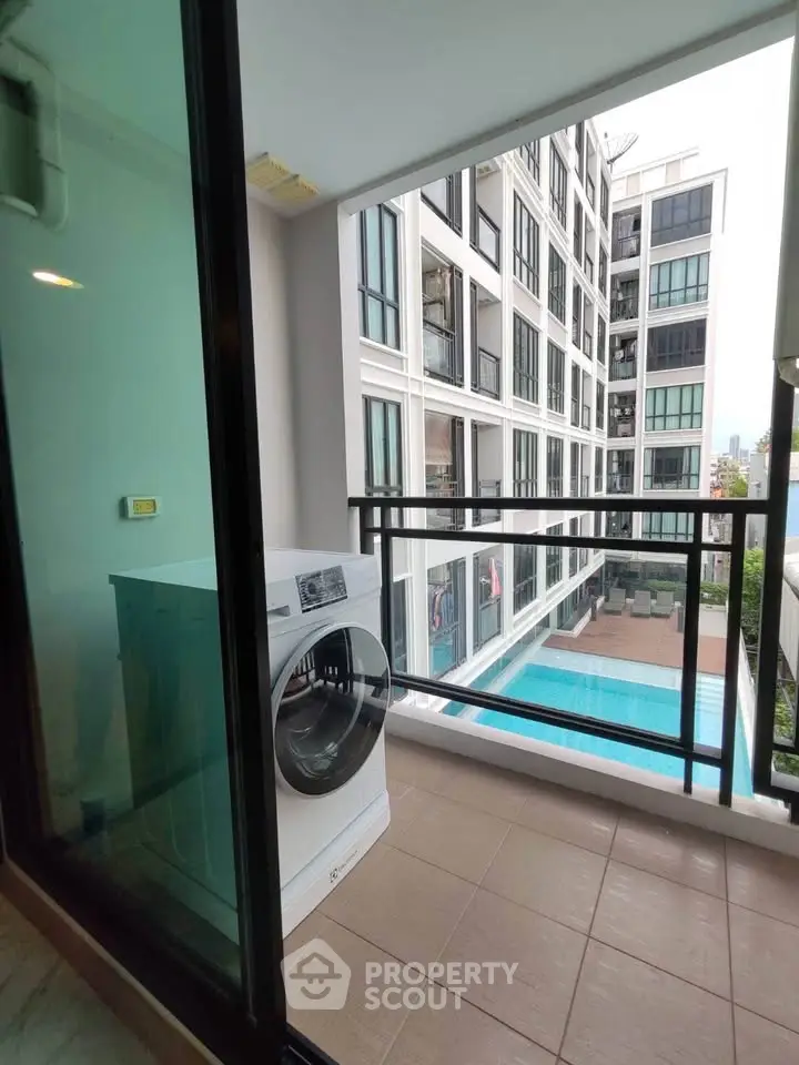 Modern apartment balcony with pool view and washing machine