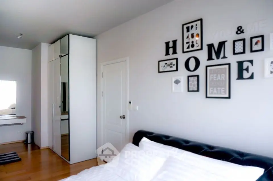 Modern bedroom with stylish decor and ample natural light, featuring a cozy bed and sleek storage solutions.
