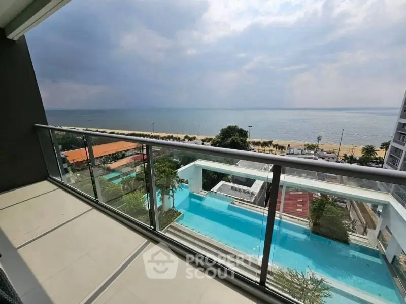 Stunning ocean view from modern balcony overlooking pool and beach, perfect for relaxation.