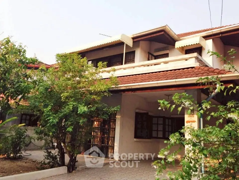 Charming two-story house with lush greenery and spacious driveway