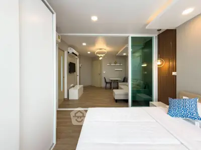 Modern open-plan bedroom with sliding glass doors and stylish living area.