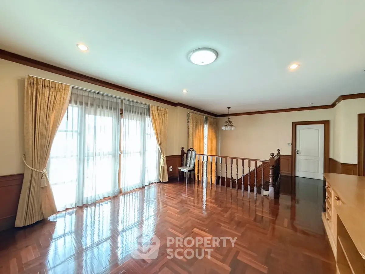 Spacious living room with elegant wooden flooring and large windows