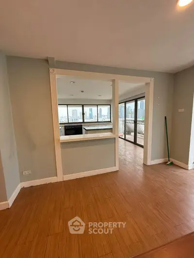 Spacious open layout living room with city view and wooden flooring