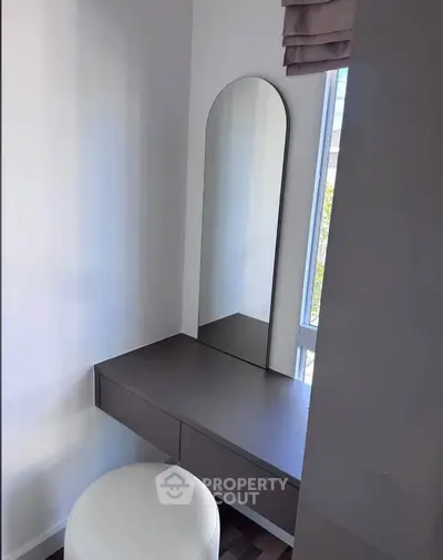 Modern bedroom corner with sleek vanity and mirror, perfect for stylish living.