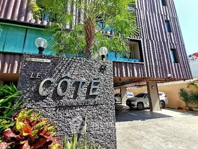 Modern apartment building with parking and lush greenery in a prime location.