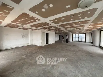 Spacious unfinished apartment with large windows and potential for customization.