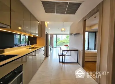 Modern kitchen with sleek cabinetry and open layout leading to dining area and balcony view.