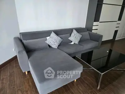 Modern living room with stylish gray sectional sofa and sleek black coffee table.