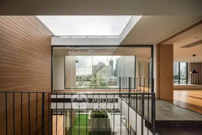 Modern multi-level home with open layout and large windows offering city views, featuring sleek wood and metal finishes.