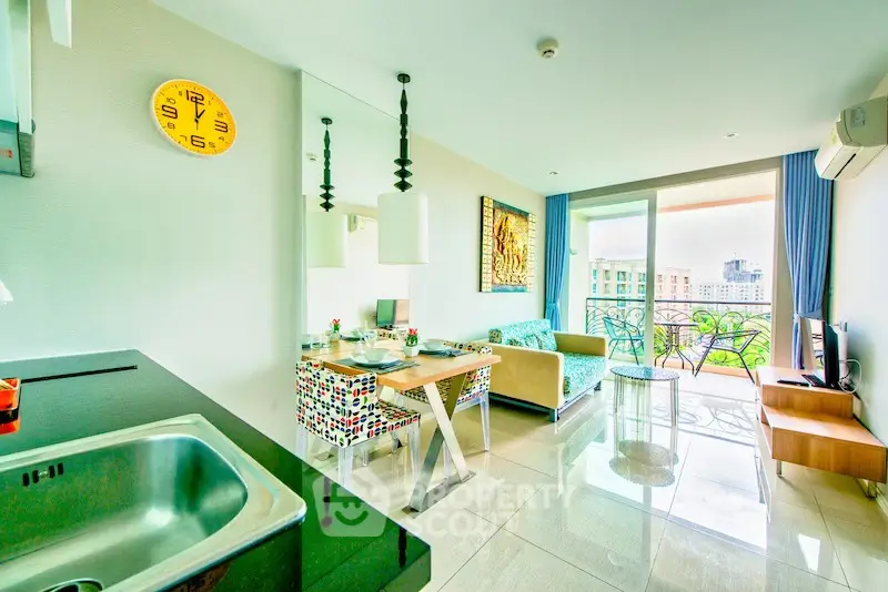 Modern living room with balcony view, stylish decor, and open kitchen layout.