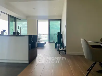 Modern open-plan living room with sleek kitchen and stunning balcony view.