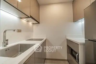 Modern compact kitchen with sleek cabinetry and integrated appliances