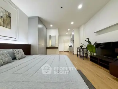 Spacious modern bedroom with sleek design and open layout, featuring a cozy bed and stylish decor.