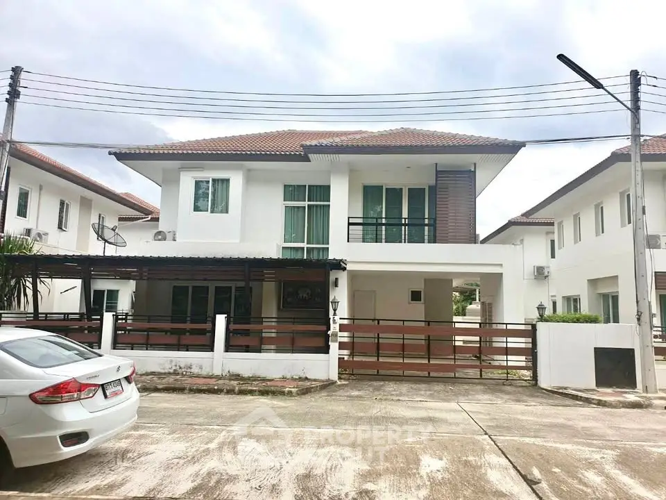 Spacious two-story modern house with large windows and driveway in a serene neighborhood.