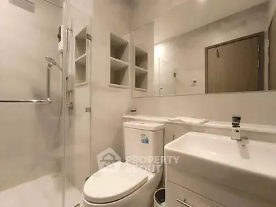 Modern bathroom with glass shower and sleek fixtures in a contemporary home.