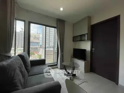 Modern living room with city view, cozy sofa, and sleek TV setup.