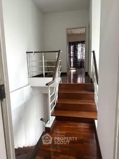 Elegant wooden staircase with modern railing in a bright home interior