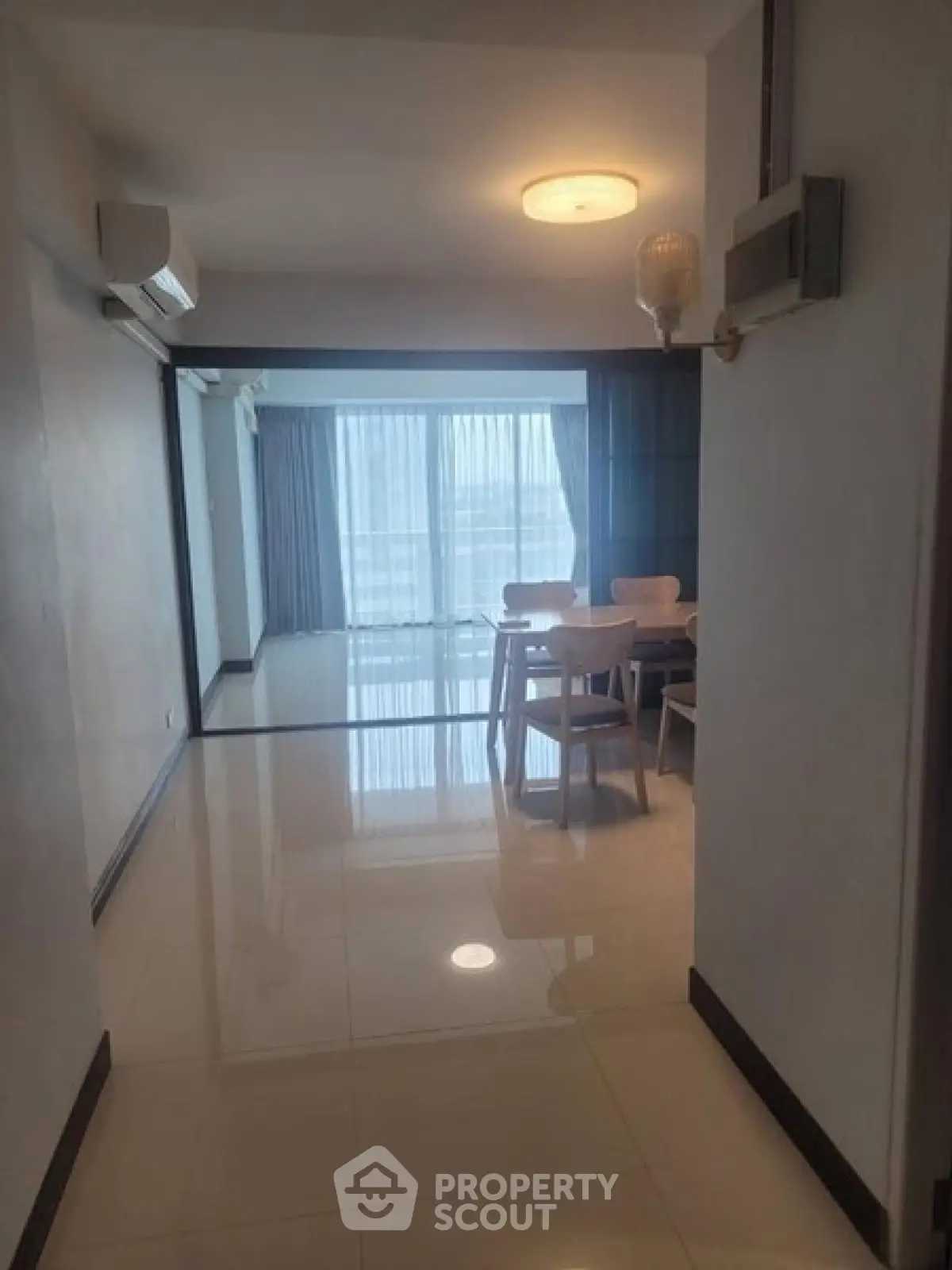Spacious living room with dining area and large windows offering natural light.