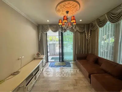 Elegant living room with chandelier and large windows offering natural light