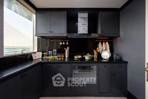 Modern kitchen with sleek black cabinetry and built-in oven