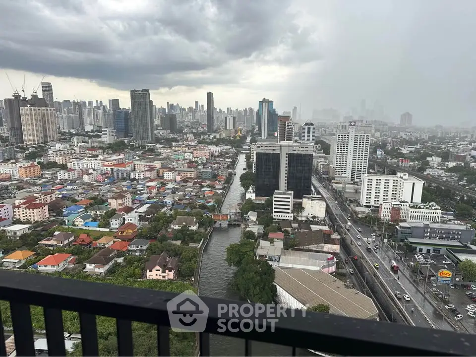 Stunning cityscape view from high-rise balcony overlooking urban skyline and river.