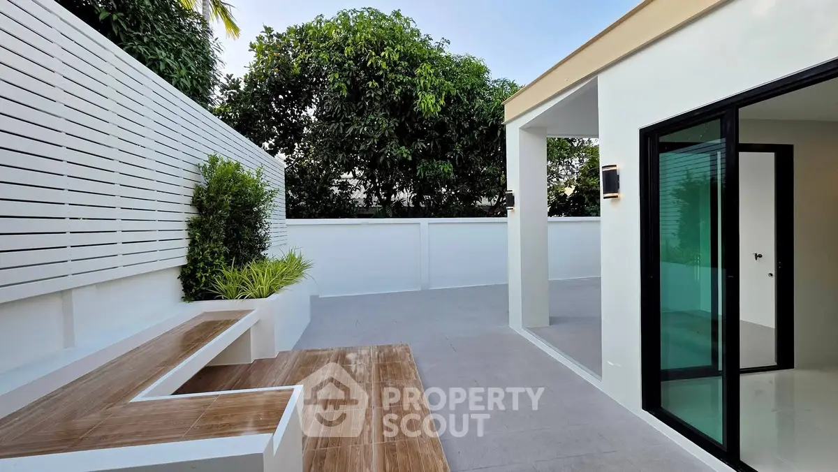 Modern outdoor patio with sleek design and lush greenery, perfect for relaxation and entertainment.