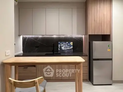 Modern kitchen with sleek cabinetry and stainless steel fridge in stylish apartment