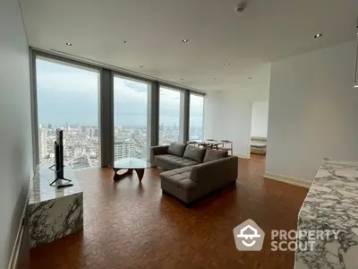 Expansive high-rise living room with polished hardwood floors and floor-to-ceiling windows offering a panoramic city view, complemented by a modern sofa set.