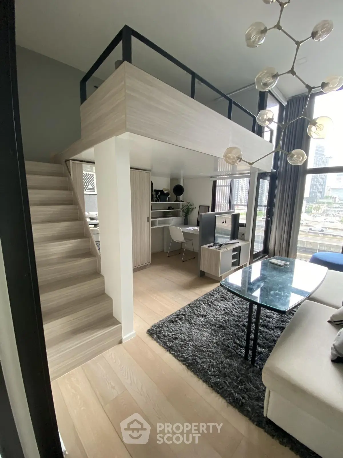 Modern loft-style living room with mezzanine, large windows, and stylish decor in urban apartment.
