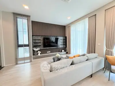 Modern living room with sleek design, large TV, and cozy seating area, perfect for relaxation and entertainment.