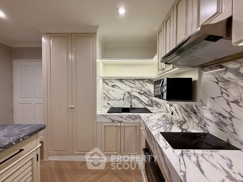Luxurious modern kitchen with marble countertops and sleek cabinetry, featuring high-end appliances and elegant design.