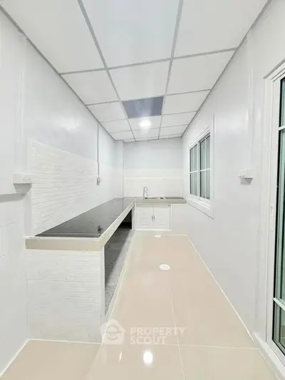 Modern kitchen with sleek countertops and tiled backsplash in a bright, minimalist design.