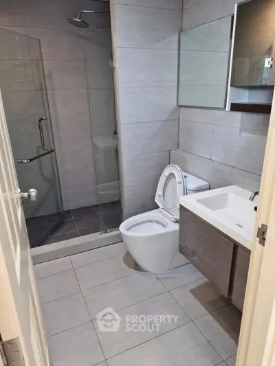 Modern bathroom with glass shower and sleek fixtures in a contemporary home.