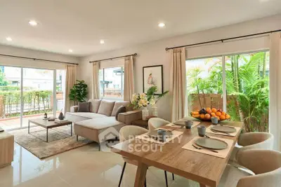 Spacious living room with modern decor and large windows overlooking lush greenery.