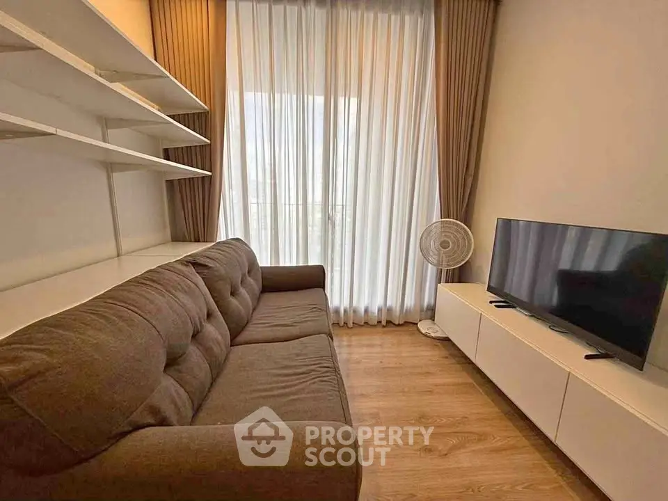 Cozy living room with modern sofa, TV, and elegant curtains in a stylish apartment.