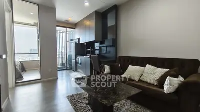 Modern living room with open kitchen and city view balcony in a stylish apartment.