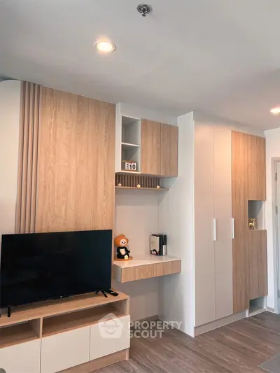 Modern living room with stylish wooden cabinetry and sleek TV setup