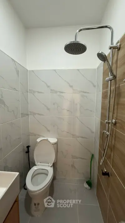 Modern bathroom with sleek shower and tiled walls, perfect for contemporary living.