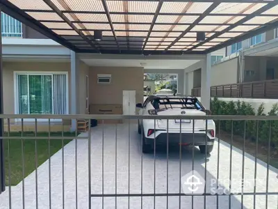 Modern house with covered carport and sleek white car in driveway