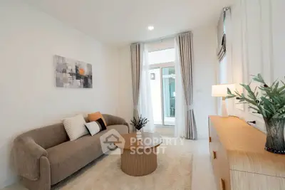 Modern living room with stylish sofa, elegant decor, and natural light from large windows.
