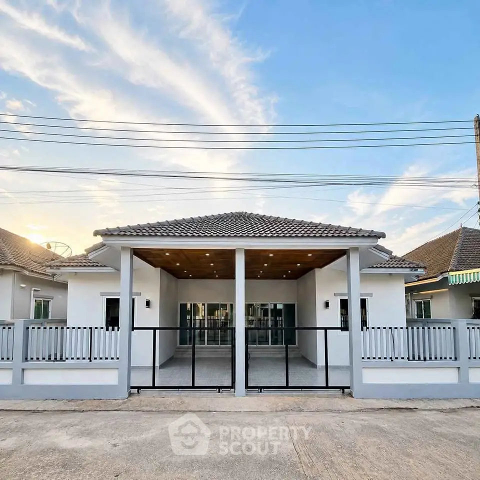 Charming single-story home with modern design and spacious front porch under a clear blue sky.