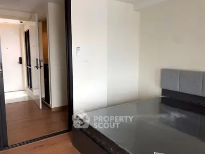 Modern bedroom with sleek design and wooden flooring in a contemporary apartment.