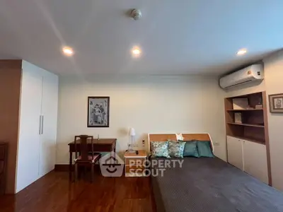 Spacious bedroom with modern furnishings and elegant decor, featuring a comfortable bed and ample storage.