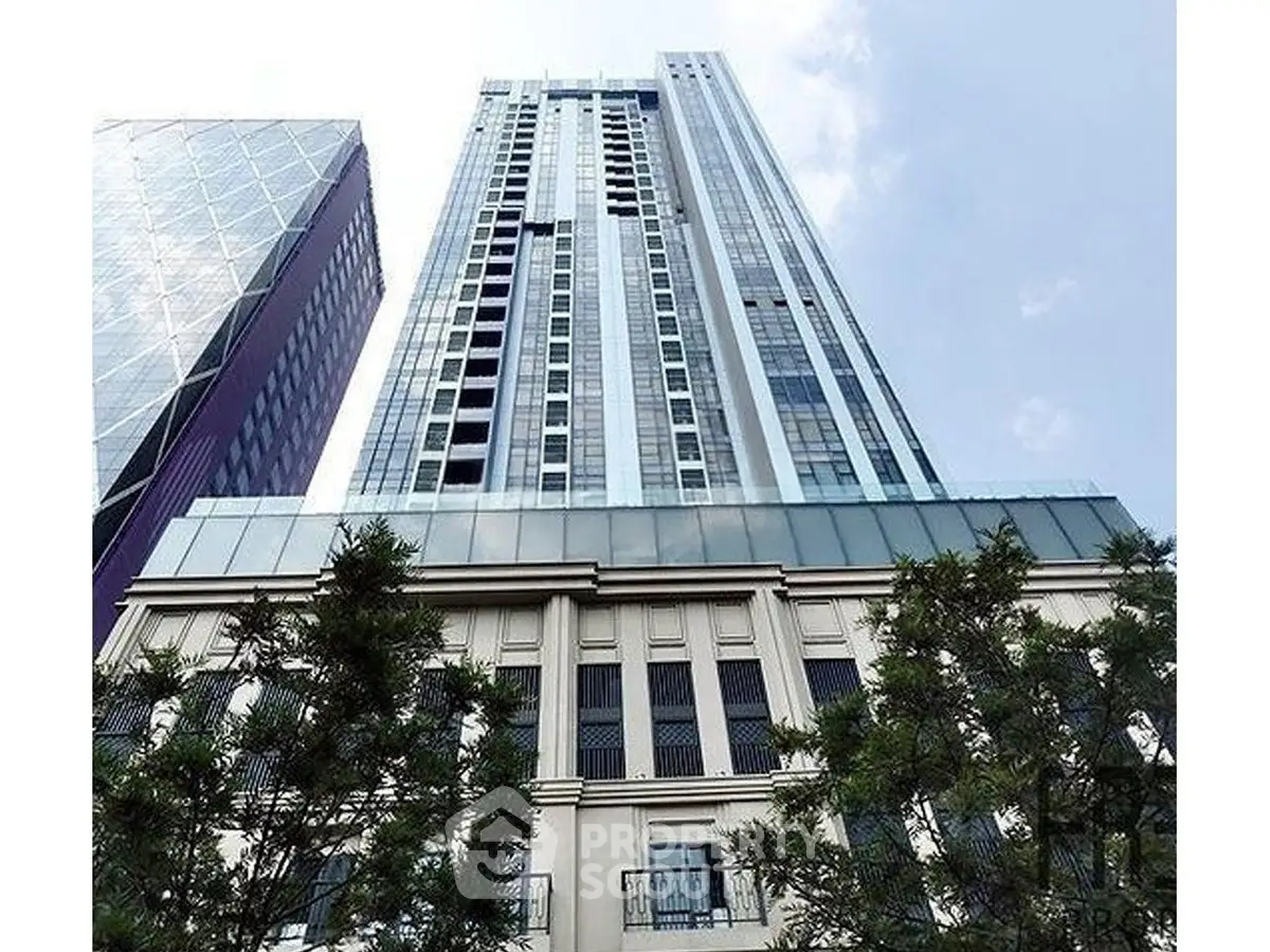 Stunning high-rise building with modern architecture and lush greenery at the base, perfect for urban living.