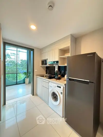 Modern kitchen with sleek appliances and a view of the garden through large windows.