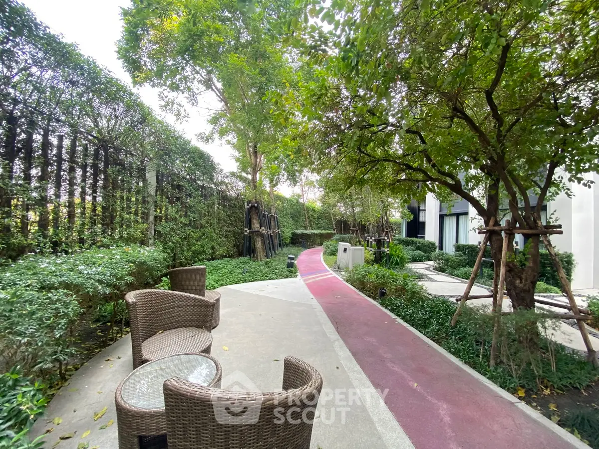 Serene garden pathway with outdoor seating in modern residential complex