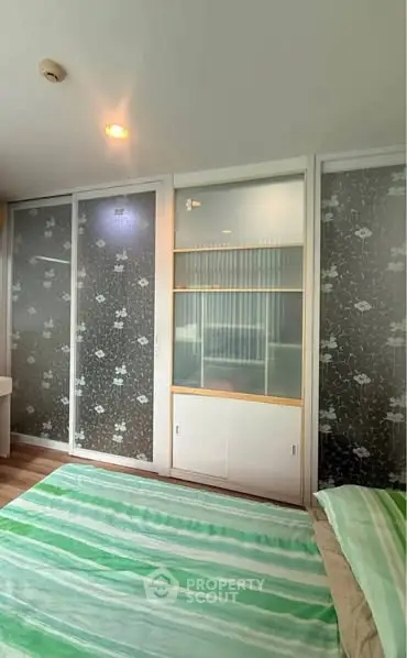 Modern bedroom with stylish sliding glass doors and cozy green bedding