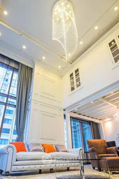 Luxurious high-ceiling living room with elegant chandelier and modern decor