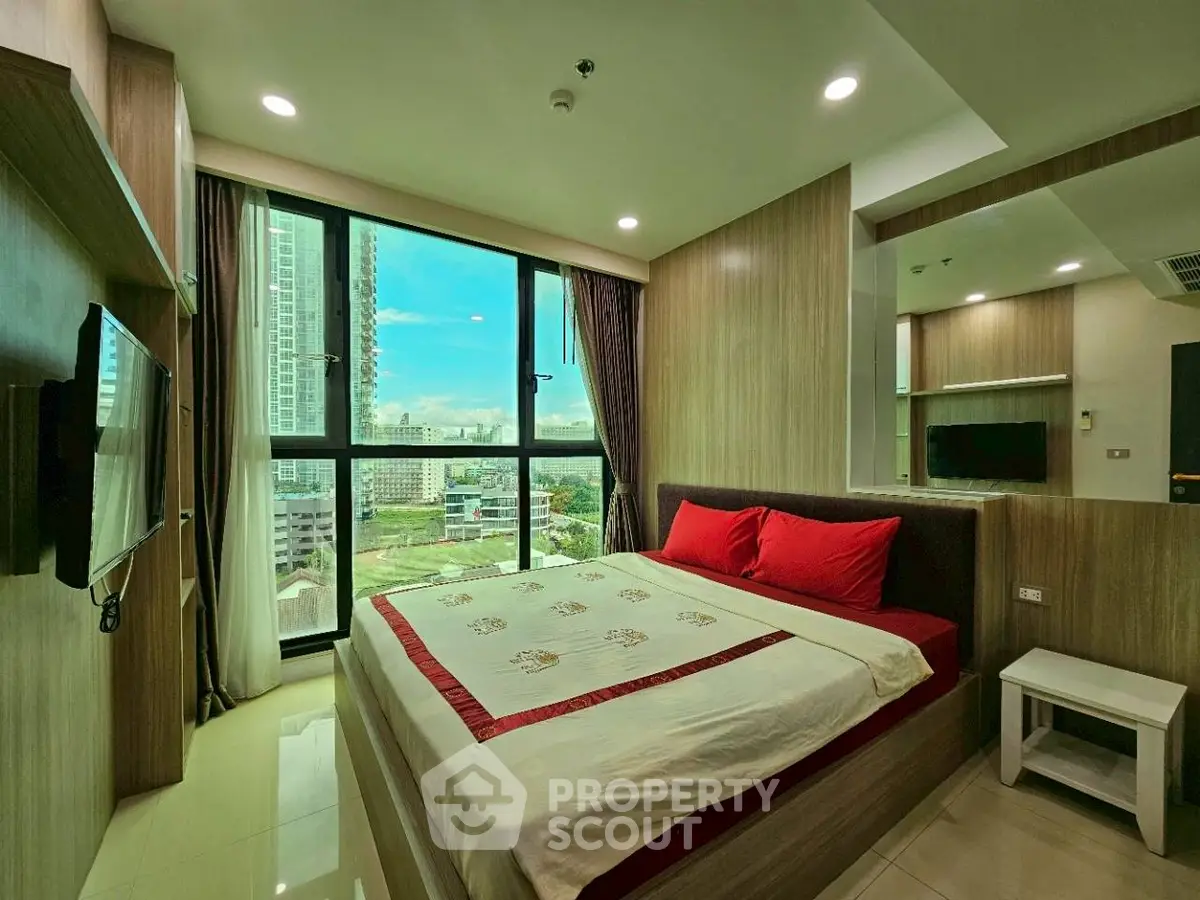 Modern bedroom with city view, featuring large windows and stylish decor.