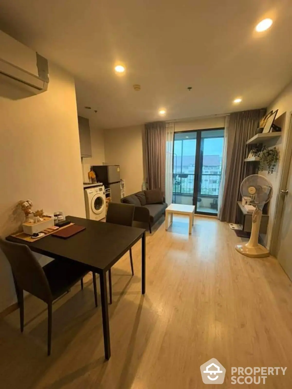 Modern living room with balcony view, featuring sleek furniture and natural light.